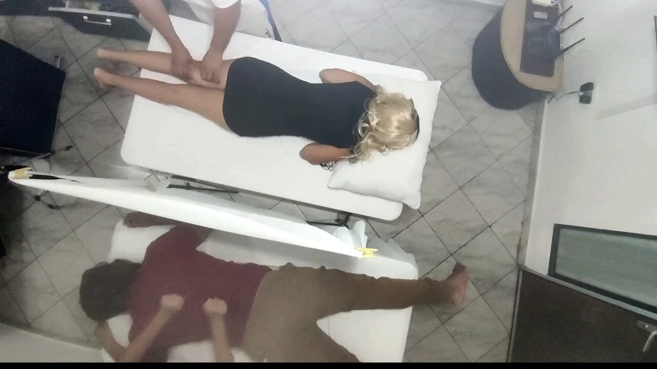 Massagem erótica no corpo da esposa gostosa ao lado do marido no salão de massagem para casais, foi gravada.